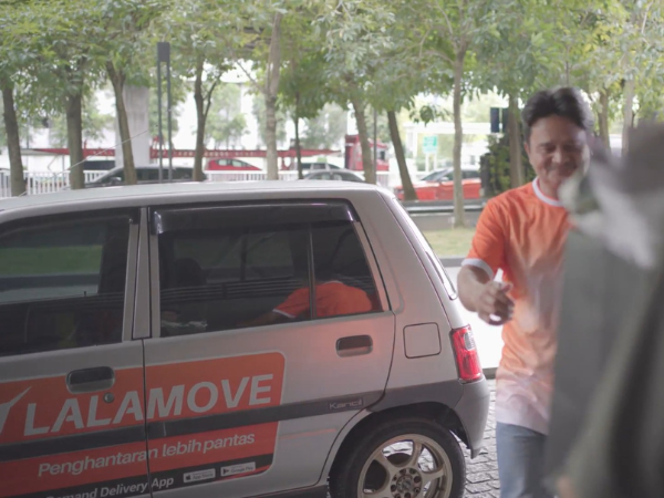 50Gram staff hands over some flowers to Lalamove driver partner for a Valentines Day delivery