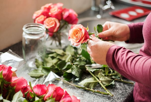 A florist arranging a roses bouquet