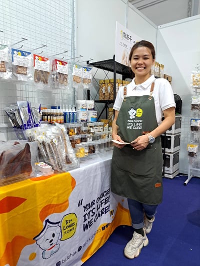 FC, a representative from bi lohas, standing in front of her booth at the pet expo