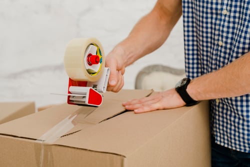 crop-man-packing-box-with-sticky-tape_23-2147758726