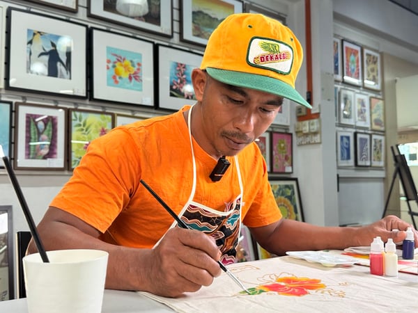 Muzaisyam sedang mewarna batik