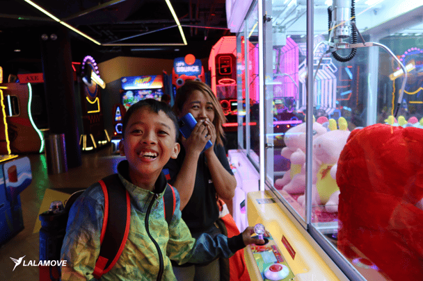 Lalamove female driver smiles with her kid at Timezone