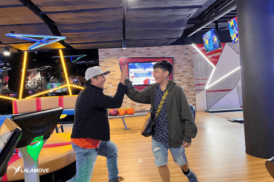 Lalamove driver high-fives his son at the bowling alley of TimeZone