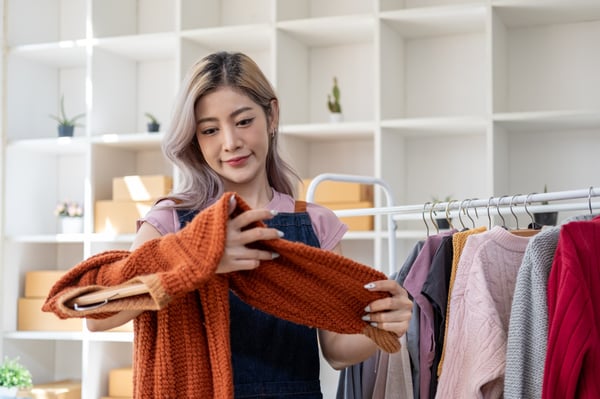 a girl looking at a cloth deciding to wear