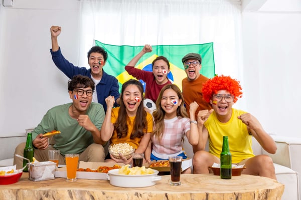a group of friends hang out together watching world cup match cheering