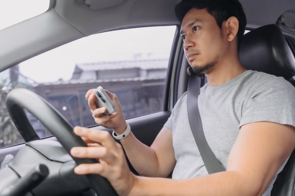 a man holding a phone while driving