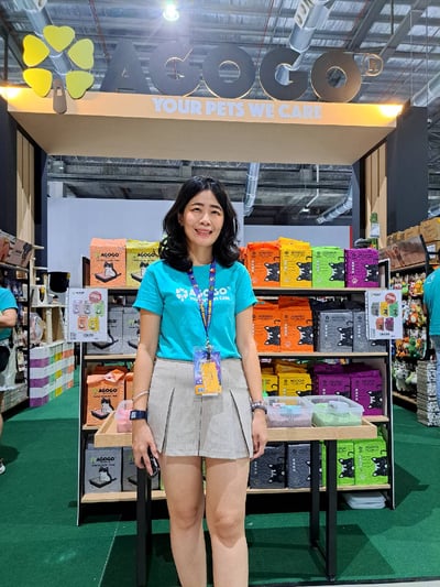 emily, the representative from lov pet bazaar sdn bhd standing in front of an arch that was transported from kuala lumpur to pet expo in johor bahru with lalamove