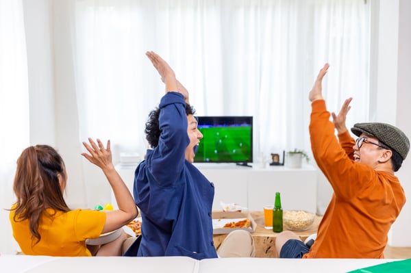 friends celebrate while watching football match