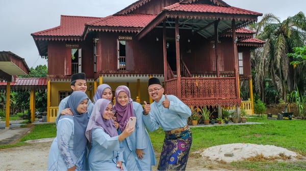 keluarga bergambar di depan rumah pada pagi raya