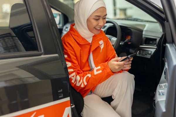 lalamove driver checking her phone wearing lalamove jacket