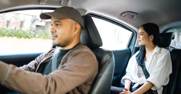 lalamove driver partner driving with female passenger in the backseat looking outside the window