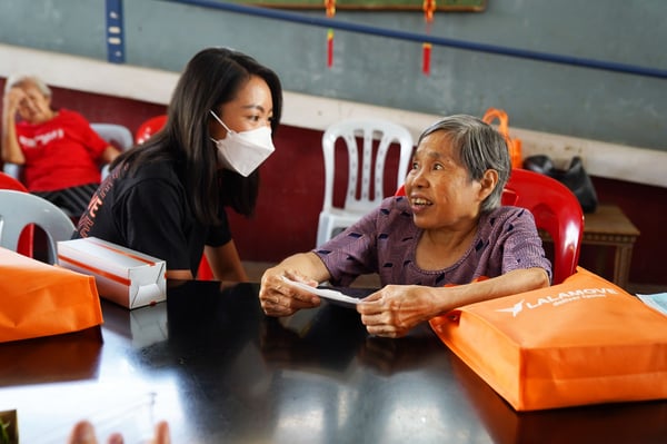 managing director of lalamove malaysia speaks to one of the senior residents of rumah charis home