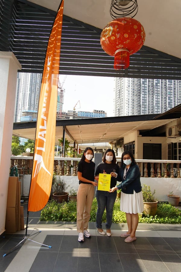 representatives from rumah charis, caring pharmacy and lalamove malaysia take a photo together